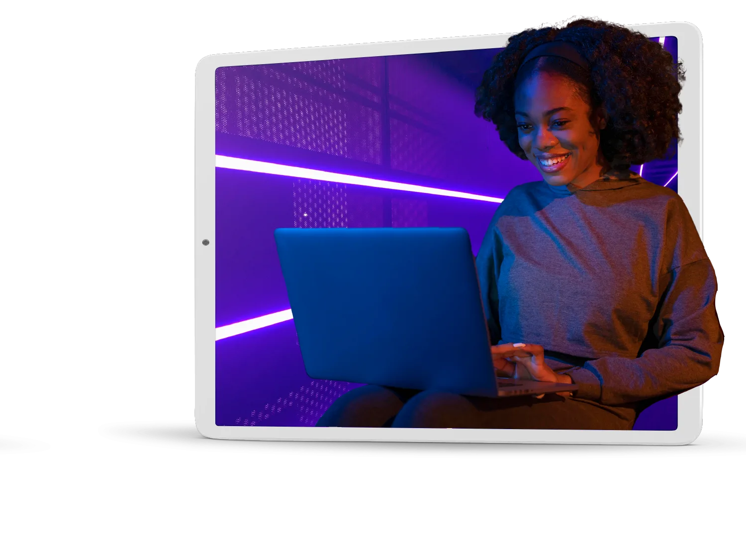 Una mujer usando una computadora portátil frente a un fondo morado.